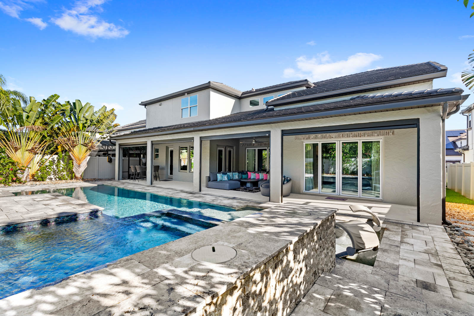 back of two story home with pool and large patio